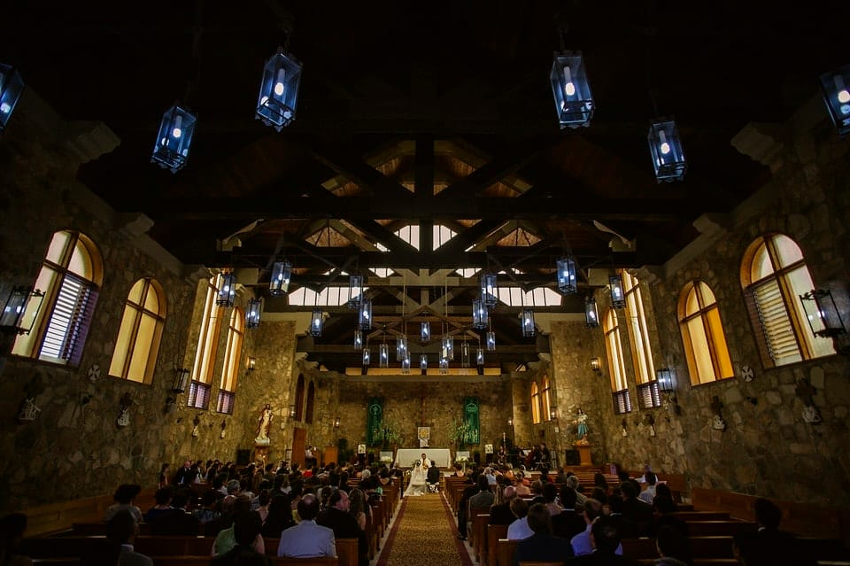 Catholic wedding ceremony interior at Iglesia de Piedra Ensenada — light through the high windows over the altar