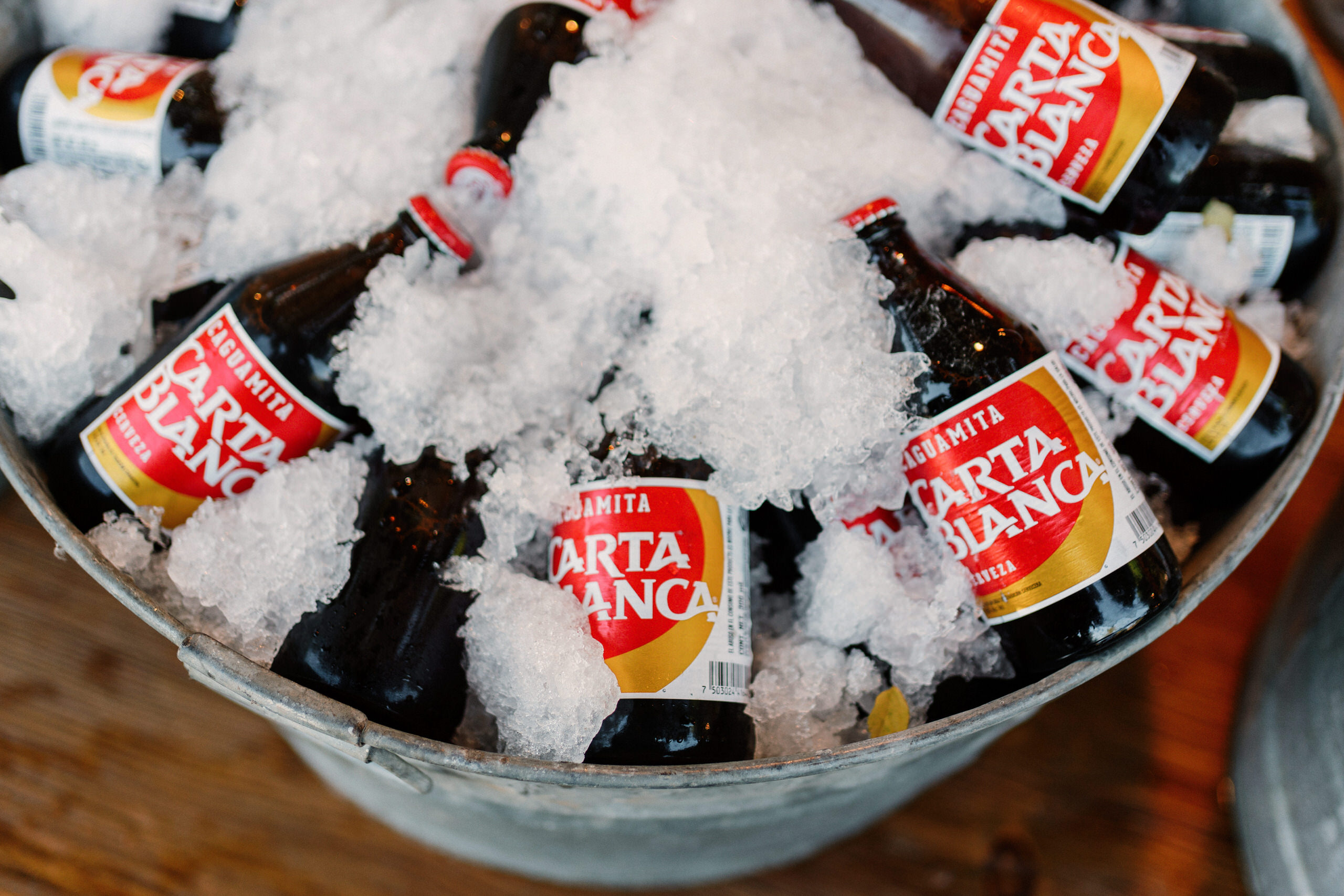 Carta Blanca beer on ice at Denise and Alfredo's Casa de Piedra wedding — the regio detail that announces the couple's Monterrey origin