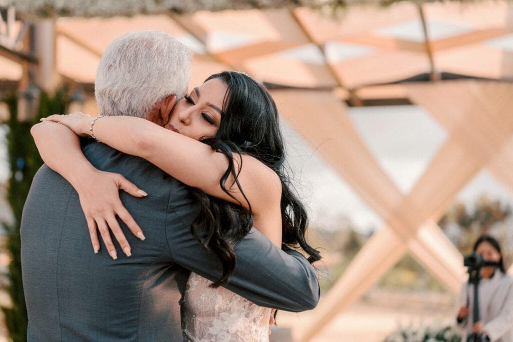 late-afternoon sun rakes between cypress rows — verify exact compass orientation against satellite | terra-cotta walls bounce a warm fill into ceremony portraits during the final hour before sunset | golden hour in Valle de Guadalupe is short, dry, and decisive — the photographer plans around it, never against it