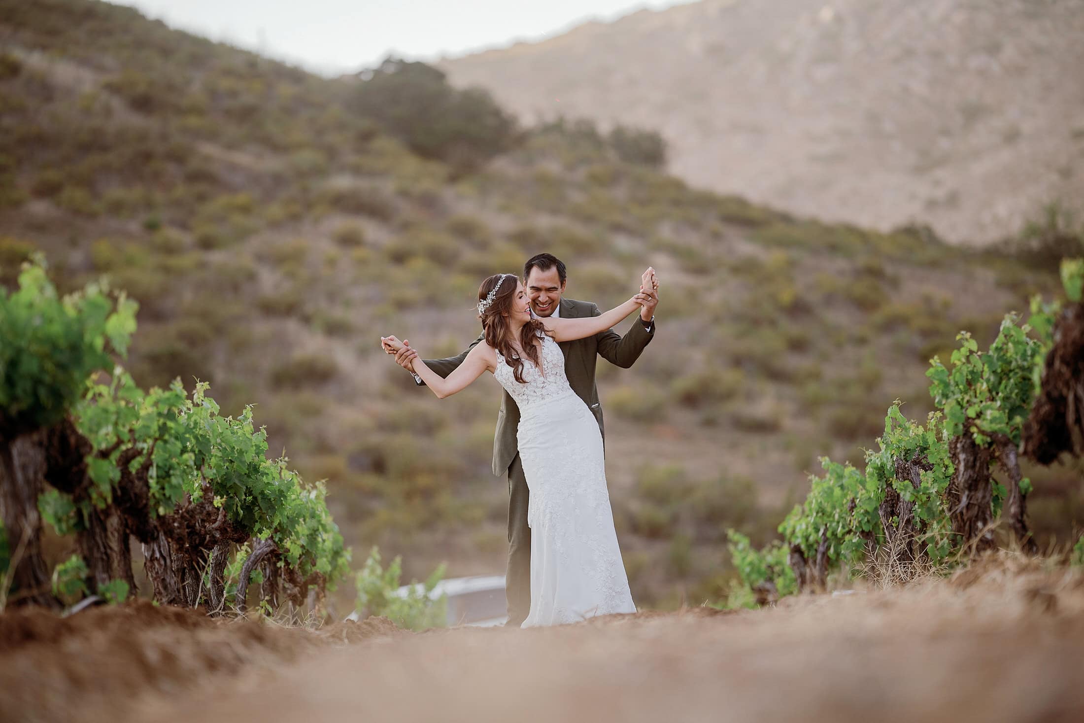 the archive returns the day — the vines at golden hour, the warm architectural surfaces, your partner standing in the working winery
