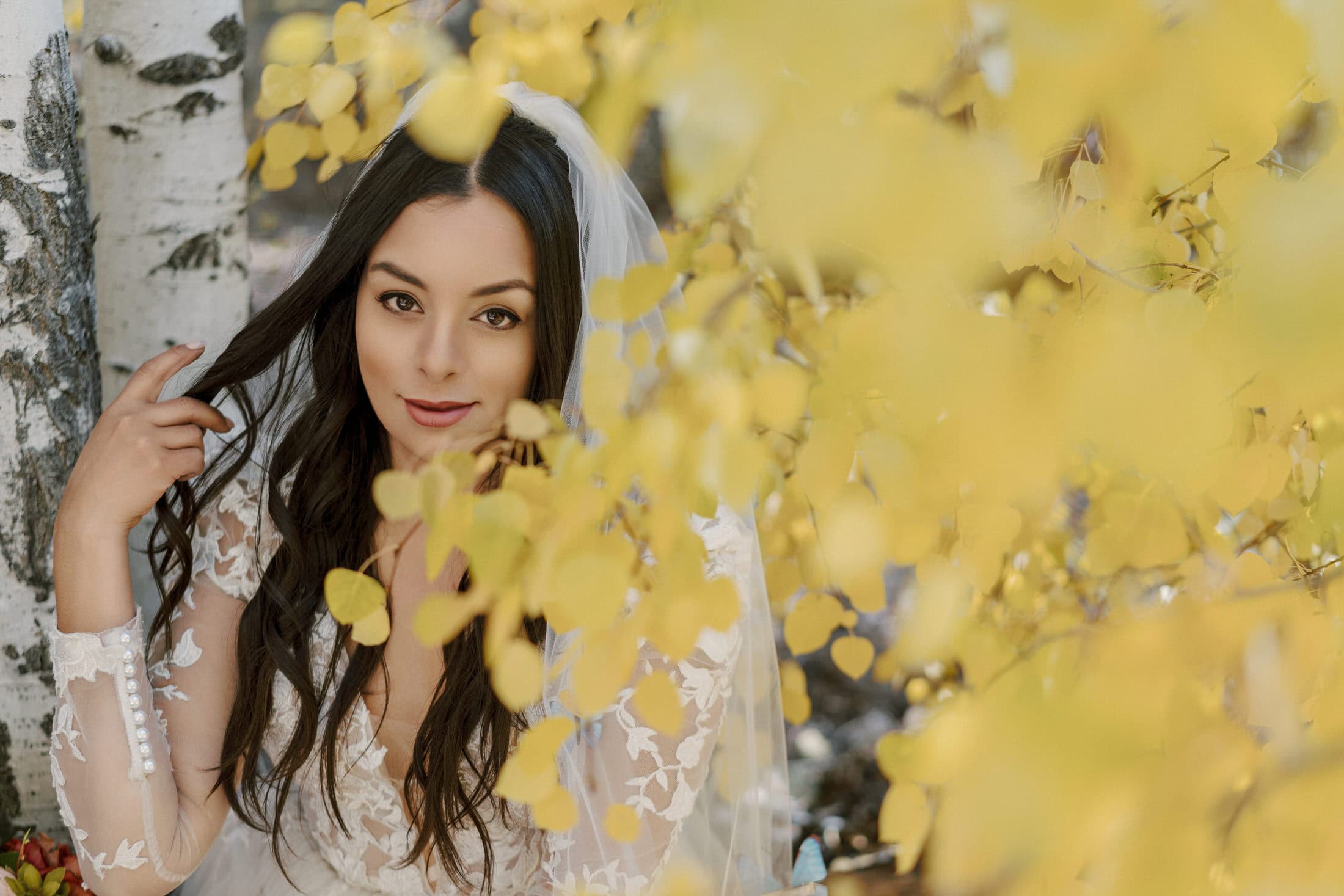 Bride portrait with autumn golden leaves — natural warmth, no performance
