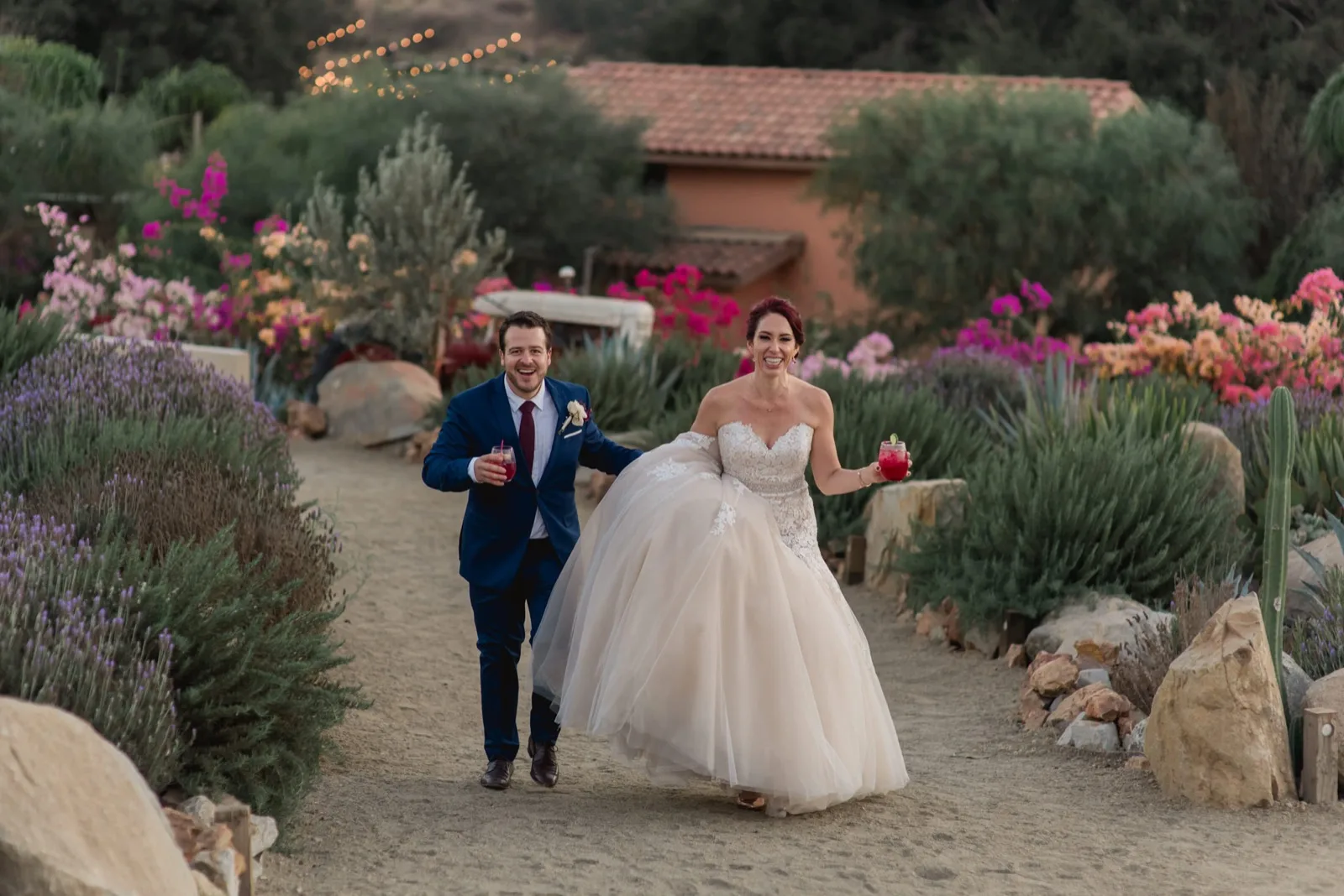 Roser and Andrés laughing while walking through vineyard garden at their Valle de Guadalupe wedding